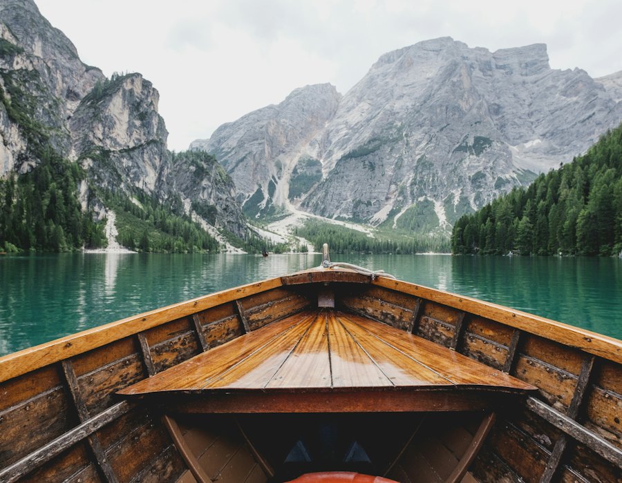 Blick aus einem Holzboot auf einen Bergsee