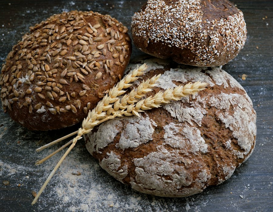 Drei frisch gebackene Brotlaibe auf einem Holztisch